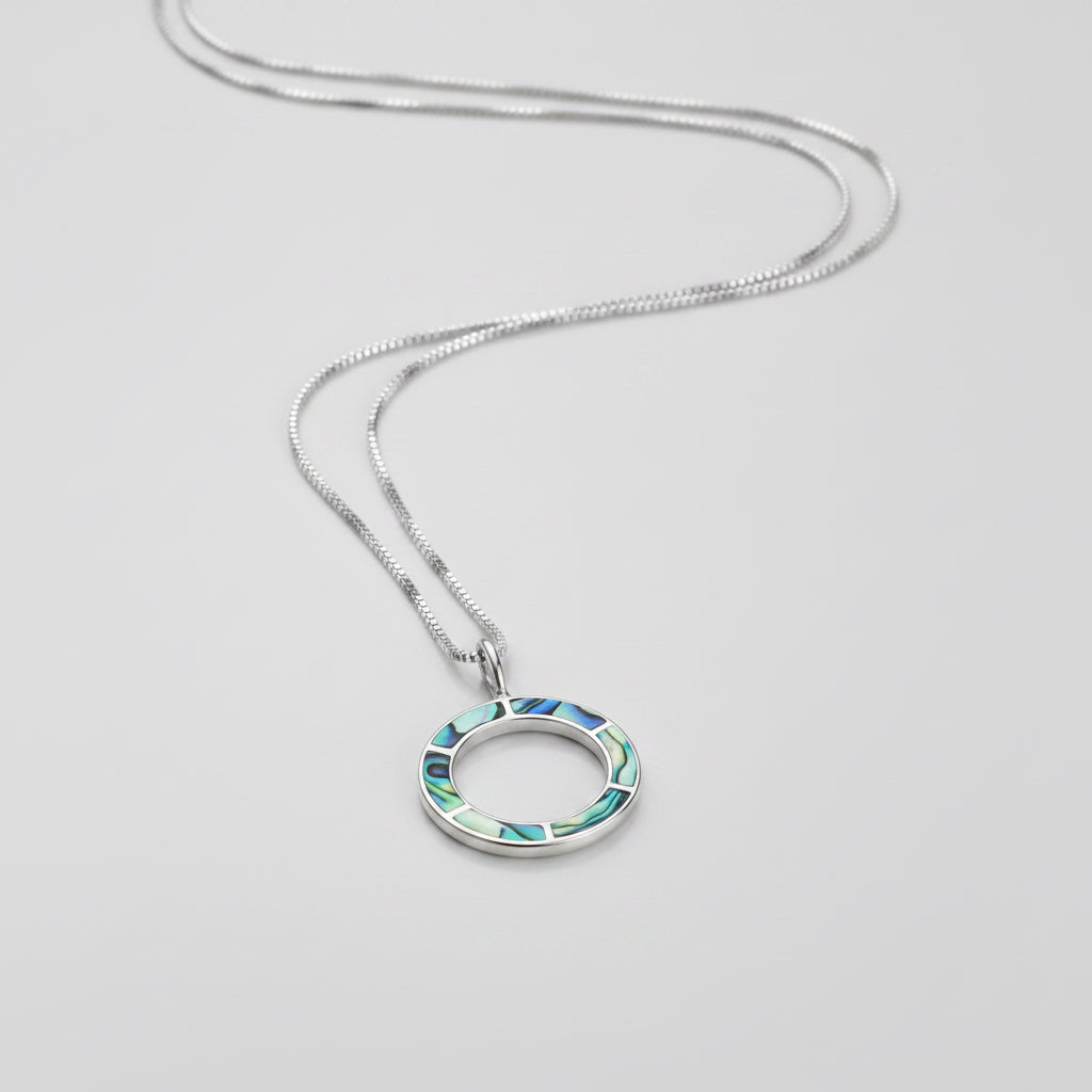 Women's Peace Collection abalone inlay circle necklace featuring a polished, round pendant with vibrant, iridescent shell details.