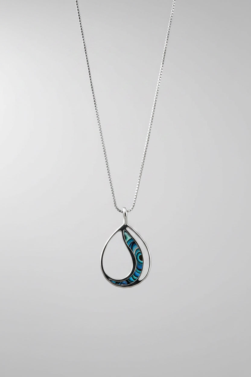 Women's Peace Collection abalone waves necklace featuring iridescent shell pendant on a delicate chain, showcasing ocean-inspired design.