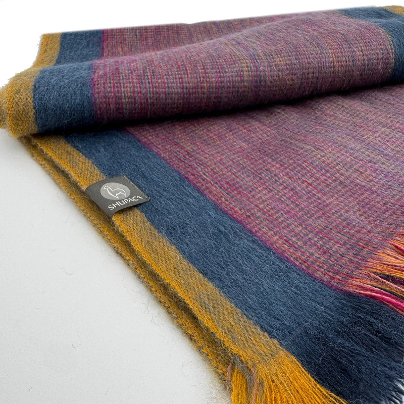 Shupaca Alpaca Sunspot scarf featuring soft, warm alpaca fibers with a vibrant sunspot pattern and fringed edges.