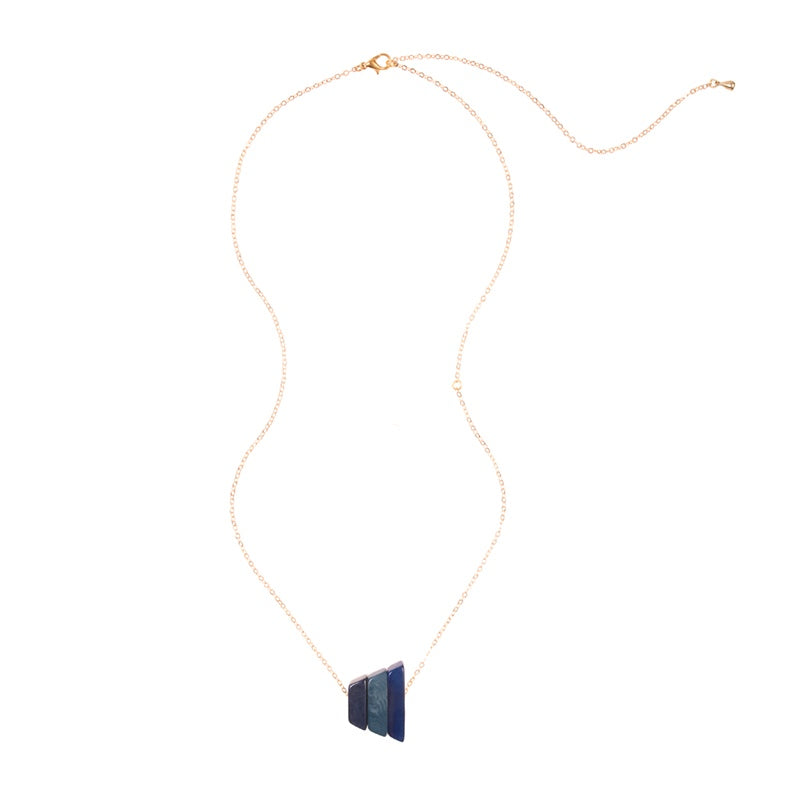 Andes Pendant from Faire Collection featuring denim blue beads and silver accents, hanging from a delicate chain.