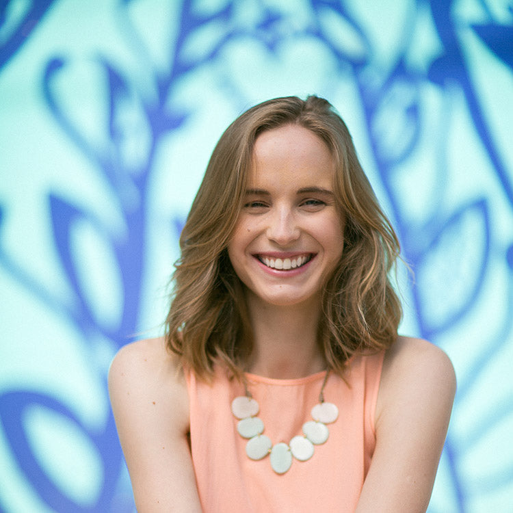 April Necklace by Faire Collection featuring a stylish melon-colored pendant on a delicate chain.