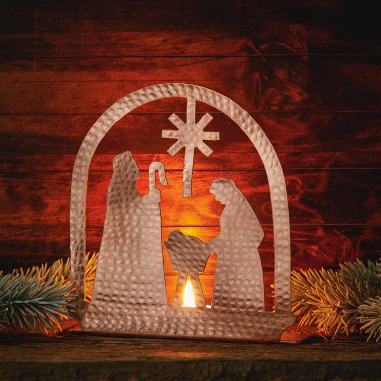 Copper tea light holder shaped like a nativity scene by Serrv, featuring detailed figures and a warm, handcrafted design.