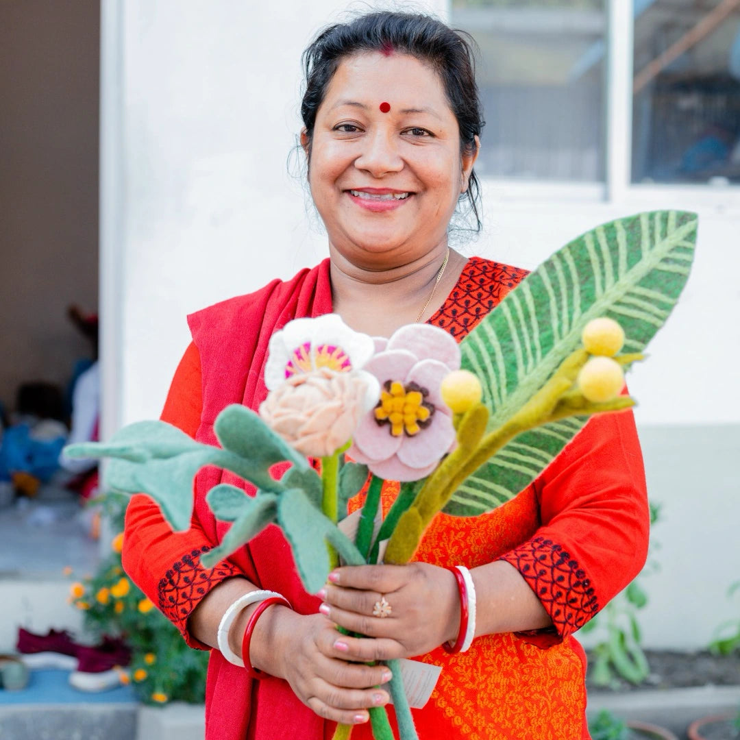 Artisan holding a bouquet of felt flowers and leaves in Nepal