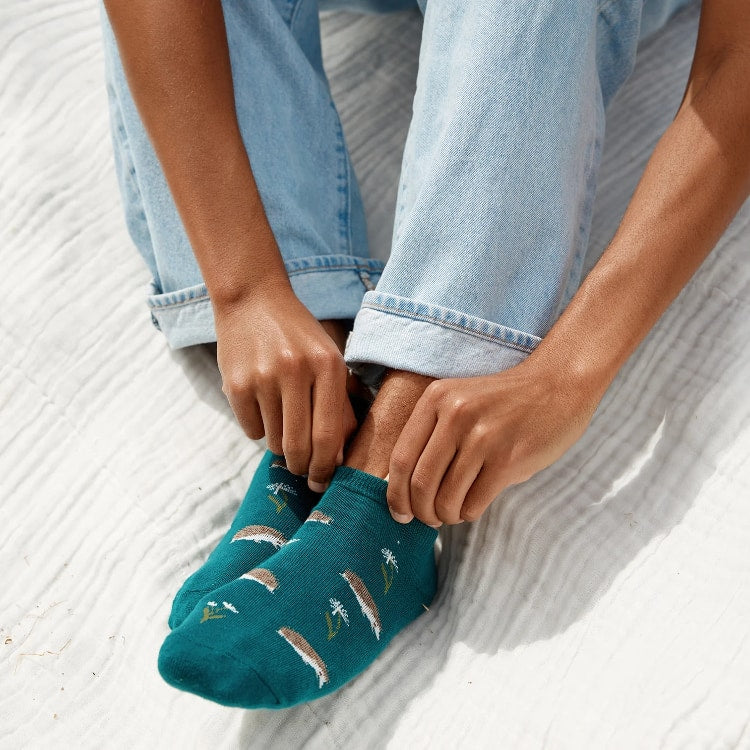 Teal ankle socks by Conscious Step featuring hedgehog designs that promote pollinator protection and sustainable fashion.
