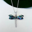 Women's Peace Collection abalone dragonfly necklace featuring a detailed, colorful pendant on a delicate chain.