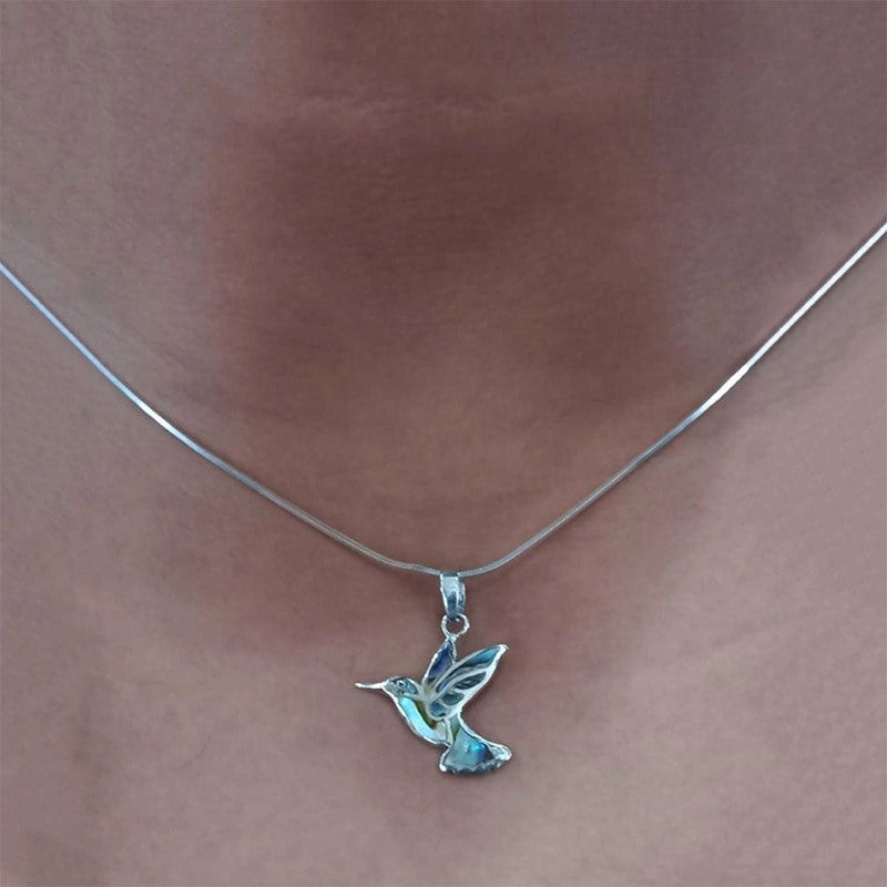 Abalone hummingbird necklace from Women's Peace Collection featuring a colorful, detailed pendant on a delicate chain.