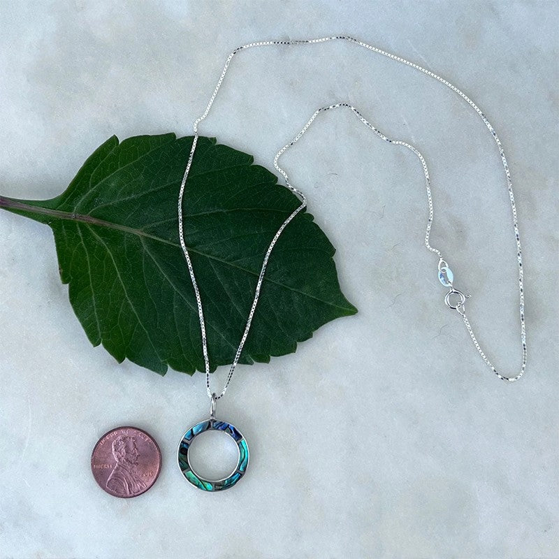 Women's Peace Collection abalone inlay circle necklace featuring vibrant, iridescent shell in a stylish circular pendant.