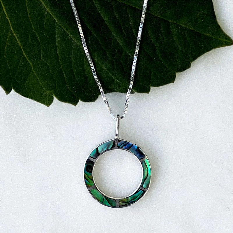 Women's Peace Collection abalone inlay circle necklace featuring a polished, round pendant with vibrant, iridescent shell details.