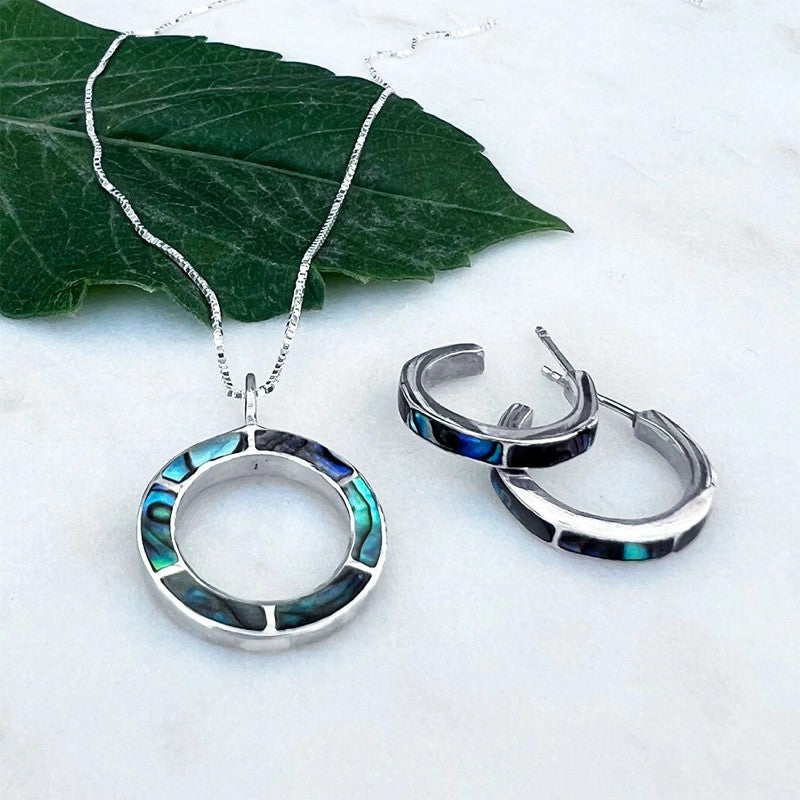 Women's Peace Collection Abalone Inlay Huggies earrings with polished silver hoops and iridescent abalone shell accents