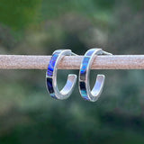 Women's Peace Collection abalone inlay huggie earrings featuring smooth gold hoops with colorful shell accents.