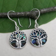 Women's Peace Collection abalone earrings featuring a detailed tree of life design, showcasing iridescent shell accents.