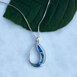 Women's Peace Collection abalone waves necklace featuring iridescent shell pendant on a delicate chain, showcasing ocean-inspired design.
