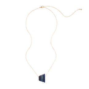 Andes Pendant from Faire Collection featuring denim blue beads and silver accents, hanging from a delicate chain.