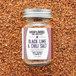 Burlap & Barrel black lime and chili sea salt in a clear jar, showing the vibrant salt blend with lime zest and chili flakes.