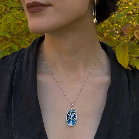 Blue Abalone Tree of Life necklace featuring a handcrafted pendant from Women's Peace Collection, showcasing vibrant abalone shell details.