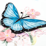 Blue butterfly and pink flower quilling card with intricate paper art, showcasing colorful handmade floral and insect designs.