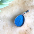 Women of the Cloud Forest Blue Morpho butterfly wing necklace featuring a vibrant, detailed butterfly wing pendant on a delicate chain.