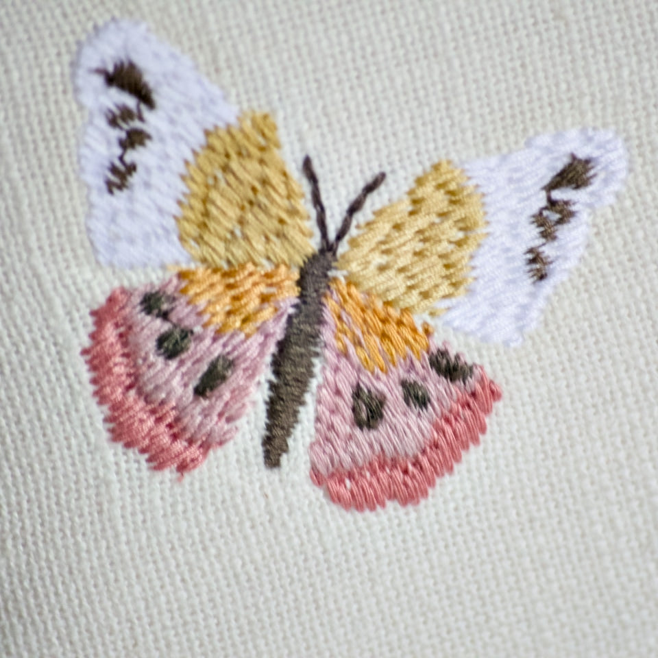 Natural Habitat embroidered pillow featuring colorful butterfly designs, measuring 12x16 inches, with detailed butterfly embroidery on fabric.