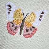 Natural Habitat embroidered pillow featuring colorful butterfly designs, measuring 12x16 inches, with detailed butterfly embroidery on fabric.