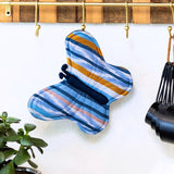Colorful butterfly-shaped potholder from Upavim with woven fabric and loop for hanging, ideal for kitchen use.