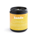 Kandu Cardamom Spice 8oz glass candle with a warm, aromatic scent and decorative label, perfect for adding cozy ambiance to any space.