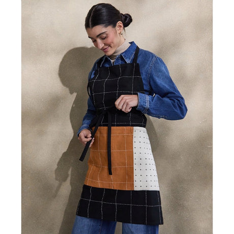 Organic cotton charcoal bib apron by Anchal, featuring adjustable neck strap and front pocket for kitchen or craft use.