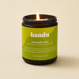 Kandu citronella mint candle with a green label on a beige background