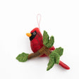 Felt red cardinal on a branch ornament, featuring detailed craftwork and vibrant red color, perfect for holiday decor.