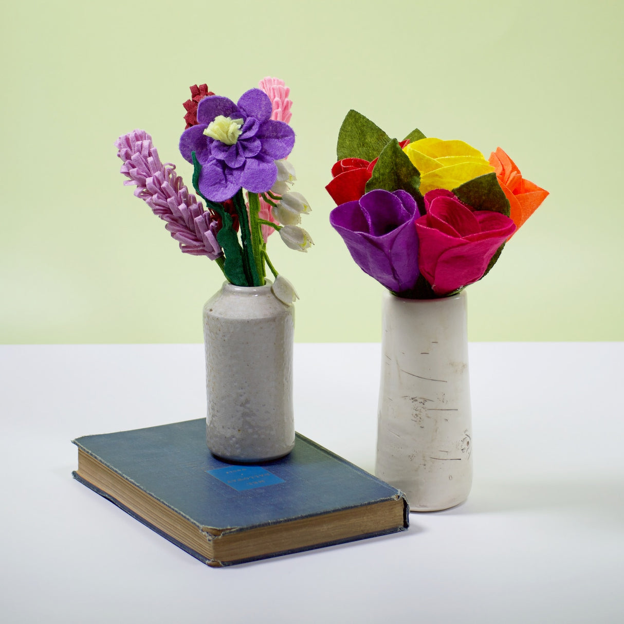 Handmade felt flower bouquet featuring tulips and green leaves in a ceramic vase
