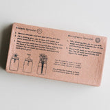 Cardboard box with avocado and microgreens sprouter instructions on a light gray background