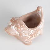 Ceramic dog-shaped planter with decorative lines on a light background