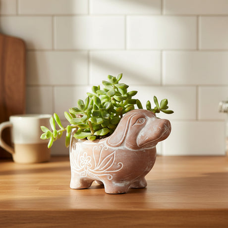 Ceramic dog-shaped planter with decorative lines on a wooden kitchen counter