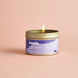 Kandu lavender candle with a purple label on a pink background