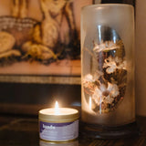 lavender cyprus candle on a table in from of a painting