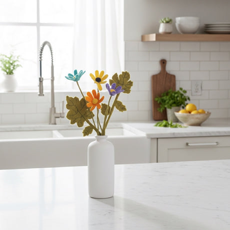 Kitchen with a white vase holding colorful felt flowers on a marble countertop.
