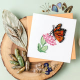 Butterfly-themed greeting card with decorative elements on a wooden surface