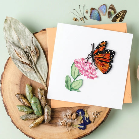 Butterfly-themed greeting card with decorative elements on a wooden surface