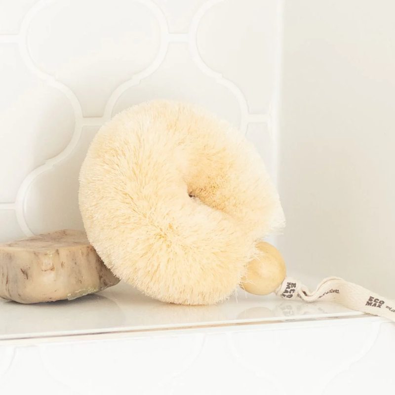 Cream-colored spa brush on a white surface