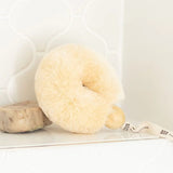 Cream-colored spa brush on a white surface