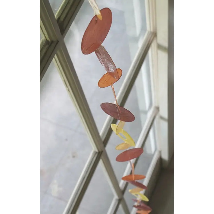 Zen-Zen Capiz shell strand with flame design, showcasing translucent, shimmering shell pieces arranged in a decorative pattern.