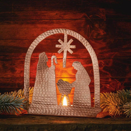Copper tea light holder shaped like a nativity scene by Serrv, featuring detailed figures and a warm, handcrafted design.
