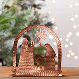 Copper tea light holder featuring a nativity scene by Serrv, crafted with intricate details for festive holiday decor.