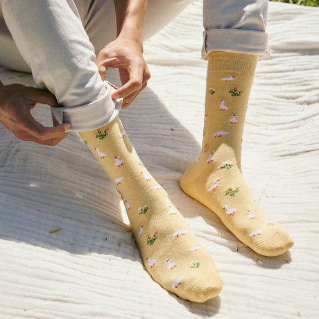 Pair of colorful Socks That Save Geese by Conscious Step featuring goose and nature-inspired patterns on soft fabric.