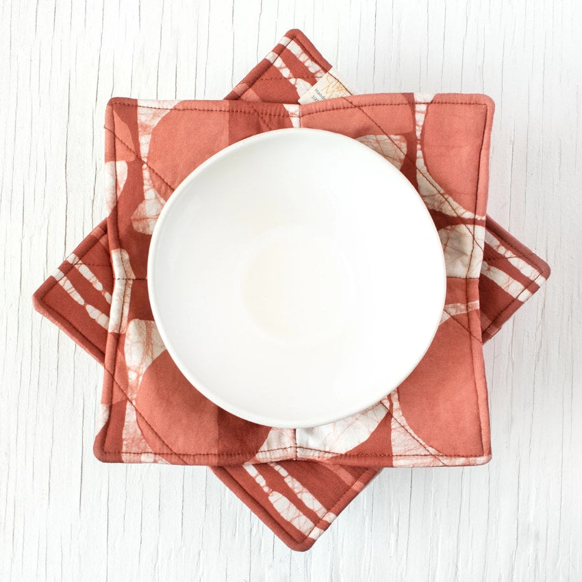 Bowl cozy in mod circle rust pattern, soft fabric cover designed to protect hands from hot bowls.