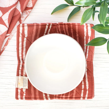 Bowl cozy in mod circle rust pattern, made of fabric to protect hands from hot bowls.