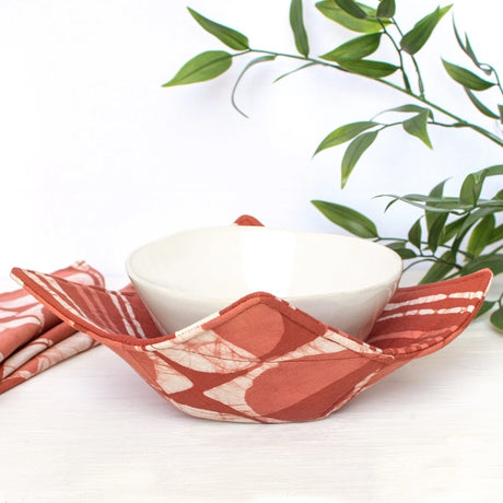 Mod circle rust bowl cozy featuring a warm, rustic fabric design perfect for protecting hands from hot bowls.